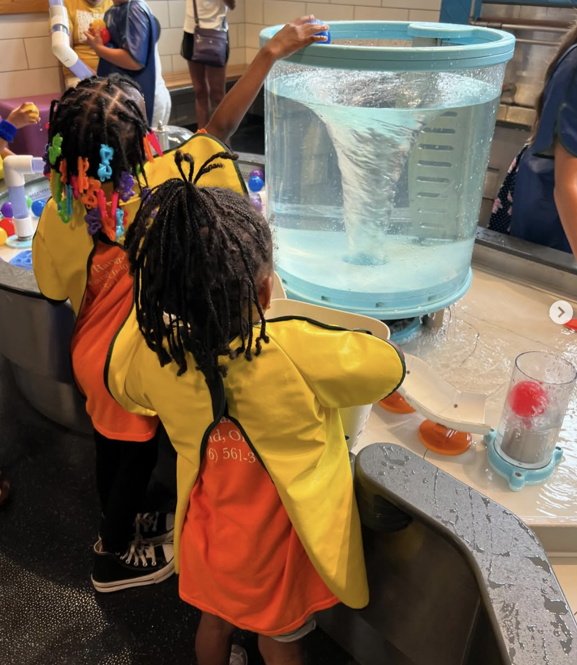 Children exploring a water tornado at a science field trip
